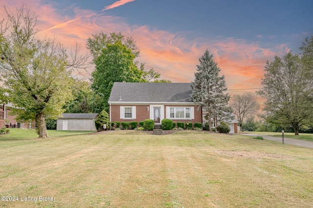 view of front of home featuring an outbuilding and a yard