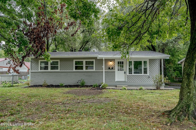 ranch-style house with brick siding, a front yard, and fence