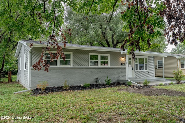 view of front of home with a front lawn and brick siding