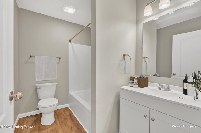 full bathroom featuring hardwood / wood-style floors, toilet, bathing tub / shower combination, and vanity