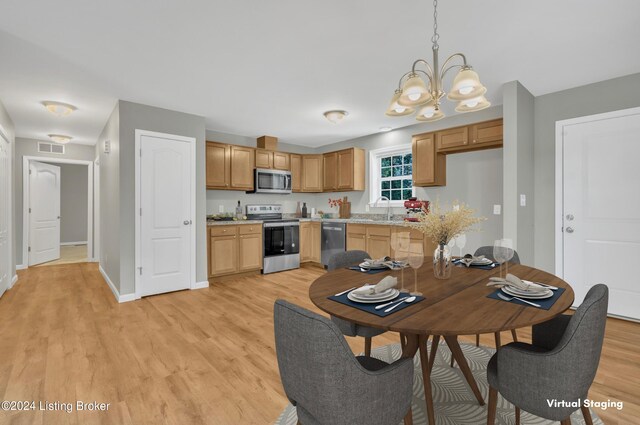 kitchen featuring light hardwood / wood-style flooring, appliances with stainless steel finishes, hanging light fixtures, sink, and a chandelier