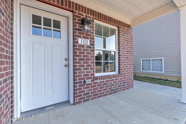 view of exterior entry featuring covered porch