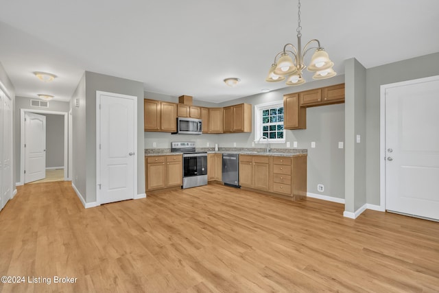 kitchen featuring light hardwood / wood-style flooring, appliances with stainless steel finishes, a chandelier, sink, and pendant lighting