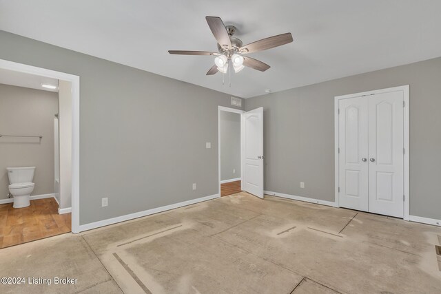 unfurnished bedroom featuring wood-type flooring, ceiling fan, a closet, and ensuite bathroom