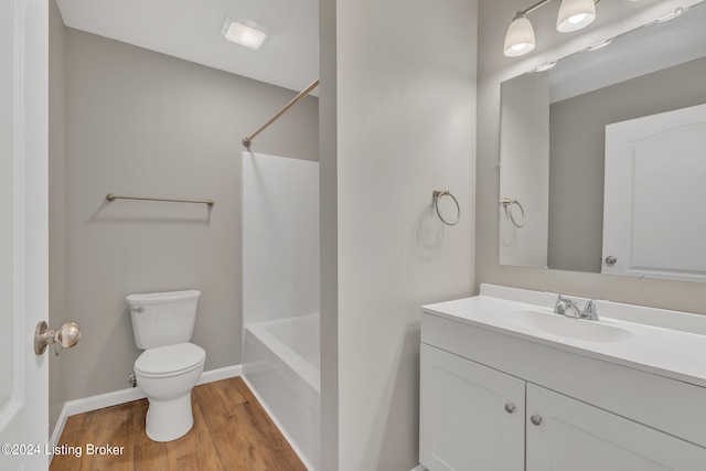 full bathroom featuring wood-type flooring, toilet, bathing tub / shower combination, and vanity