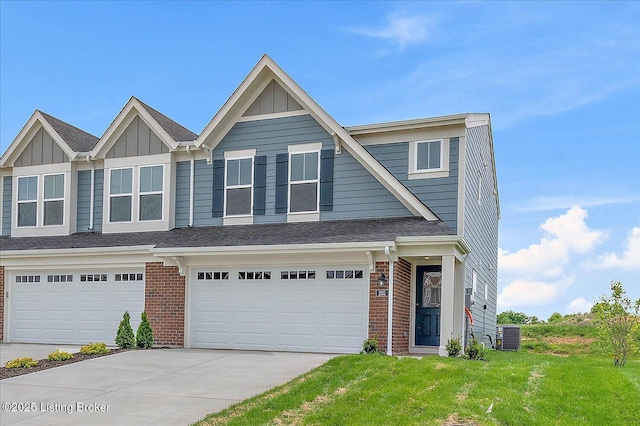 view of front of home featuring brick siding, concrete driveway, board and batten siding, a front yard, and central AC