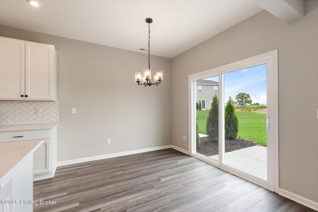 unfurnished dining area with light wood-style floors, a chandelier, baseboards, and recessed lighting