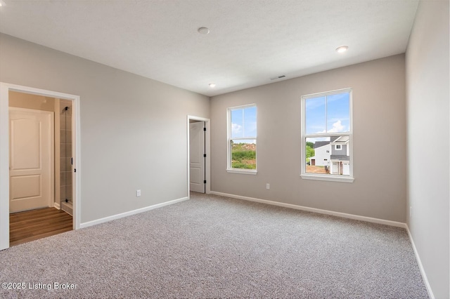 carpeted empty room with baseboards