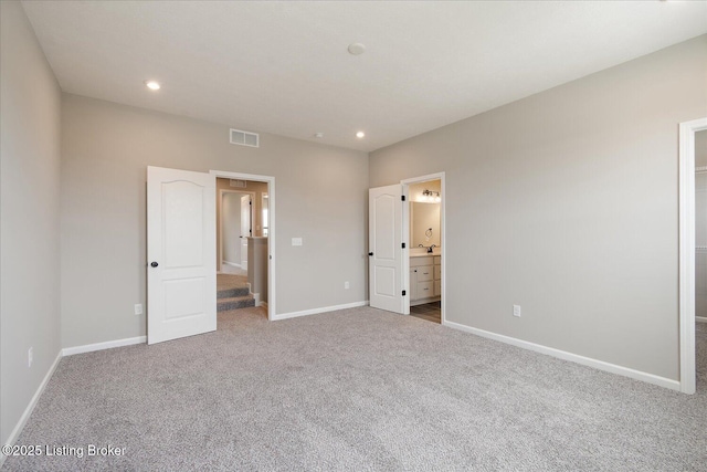 unfurnished bedroom with carpet floors, baseboards, recessed lighting, and ensuite bath