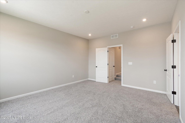unfurnished bedroom with light carpet, baseboards, and recessed lighting