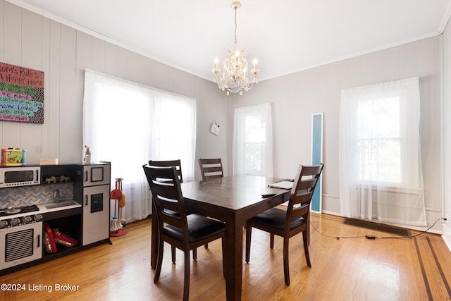 dining area with a healthy amount of sunlight, light hardwood / wood-style flooring, and a chandelier