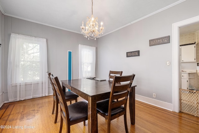 dining area featuring a wealth of natural light, crown molding, a notable chandelier, and light wood-type flooring