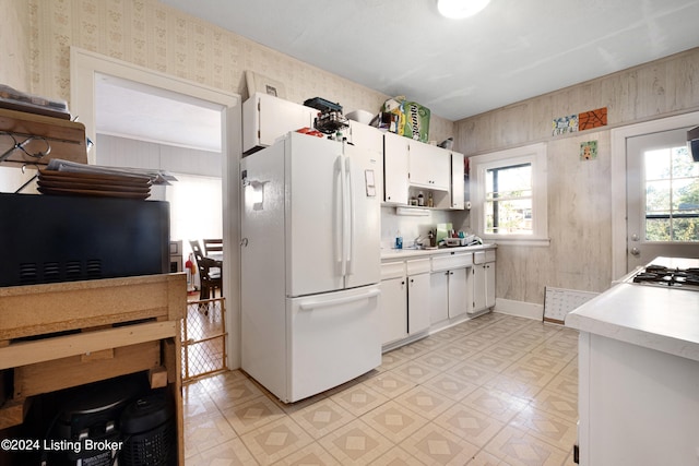 kitchen featuring white appliances and white cabinetry