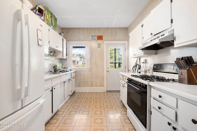 kitchen featuring sink, white appliances, and white cabinetry