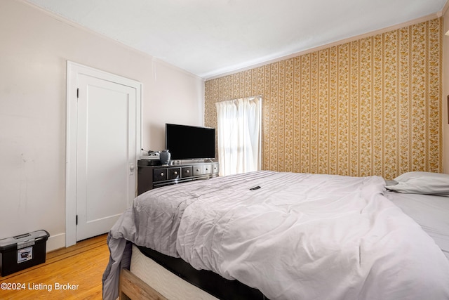 bedroom with crown molding and hardwood / wood-style flooring