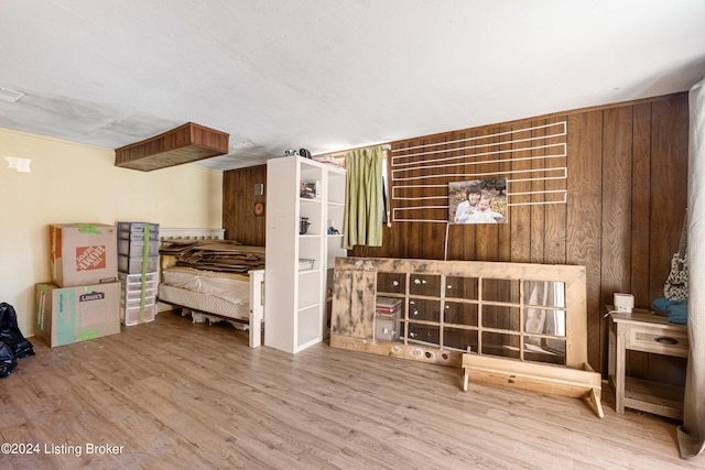 bedroom featuring wood walls and wood-type flooring