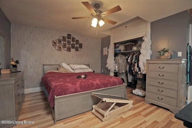 bedroom with light wood-type flooring, ceiling fan, and a closet