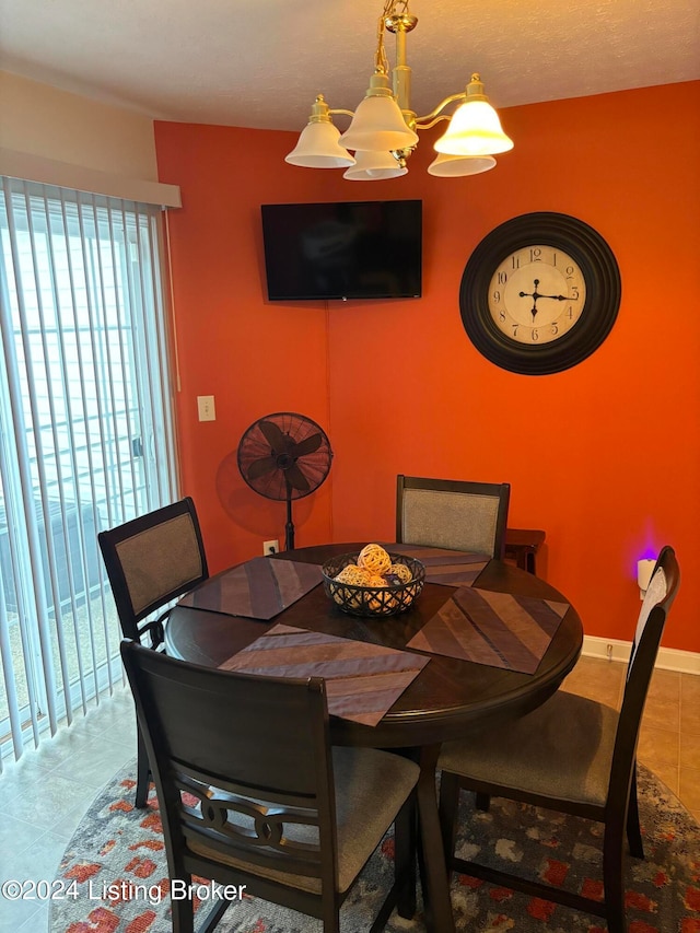 dining room featuring a healthy amount of sunlight, light tile patterned floors, and a notable chandelier