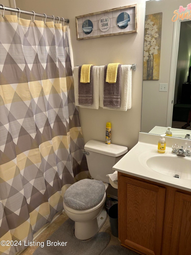 bathroom featuring a shower with shower curtain, vanity, toilet, and tile patterned floors