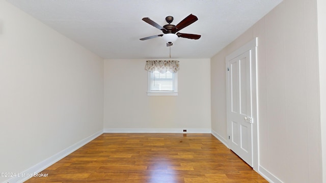 empty room with ceiling fan and wood-type flooring