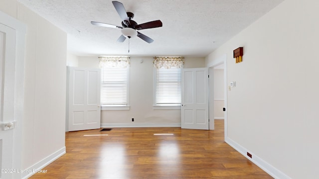 spare room with hardwood / wood-style floors, a textured ceiling, and ceiling fan