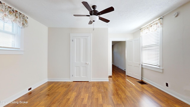 unfurnished bedroom with a textured ceiling, light hardwood / wood-style flooring, and ceiling fan