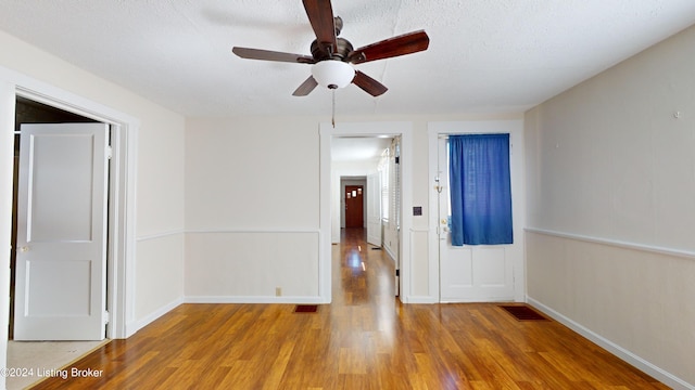 interior space with a textured ceiling, light hardwood / wood-style flooring, and ceiling fan