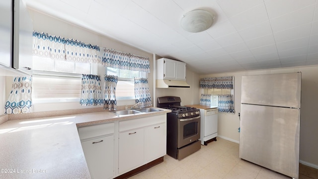 kitchen with stainless steel appliances, white cabinetry, lofted ceiling, and sink