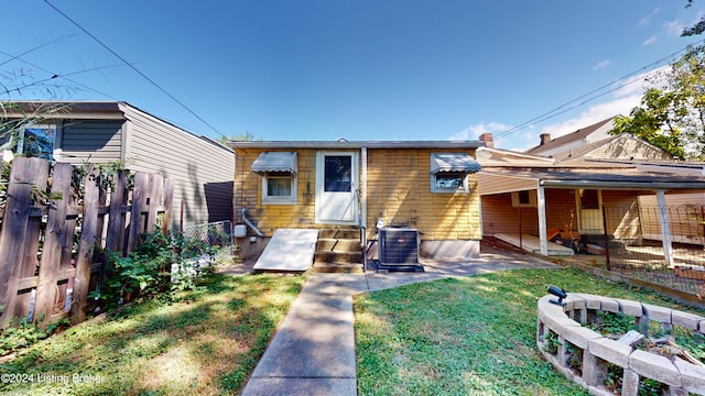 rear view of property with a yard and central AC