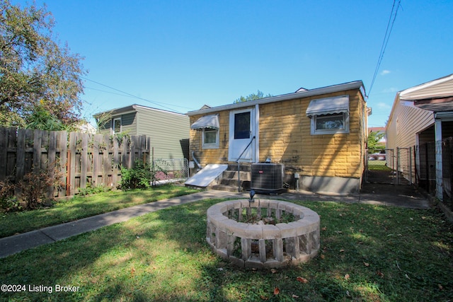 back of house with a lawn and cooling unit