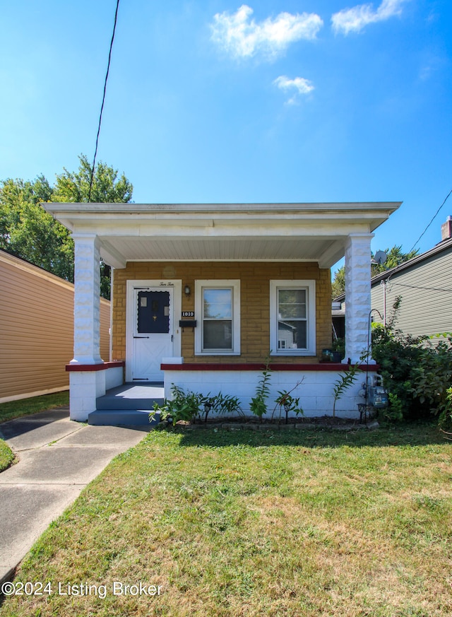 view of front of property featuring covered porch and a front lawn