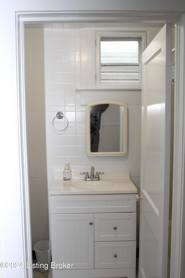 bathroom with vanity and tile walls