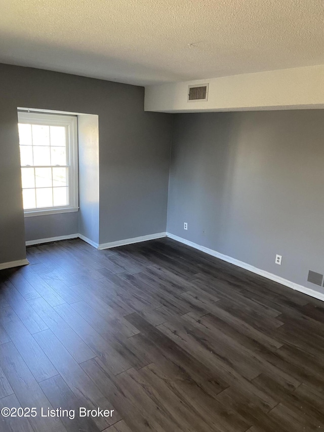 unfurnished room featuring dark hardwood / wood-style floors and a textured ceiling