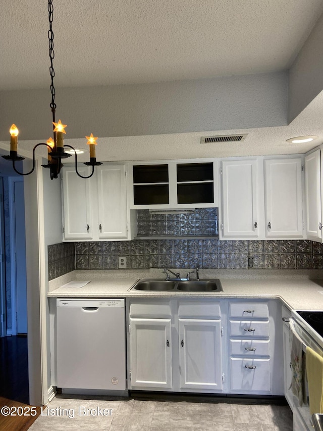 kitchen featuring pendant lighting, sink, stainless steel dishwasher, and white cabinets