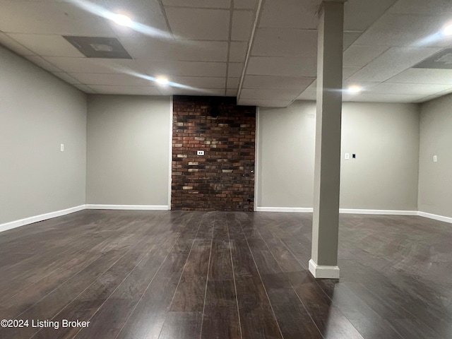 basement featuring a drop ceiling and dark hardwood / wood-style floors