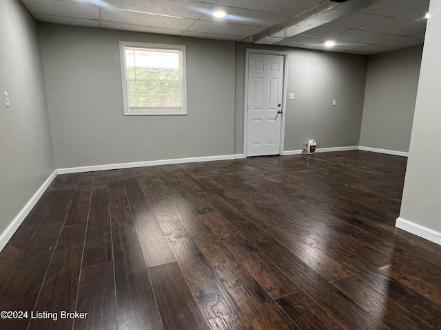 empty room featuring a drop ceiling and dark wood-type flooring