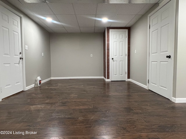 unfurnished room featuring dark hardwood / wood-style floors and a paneled ceiling