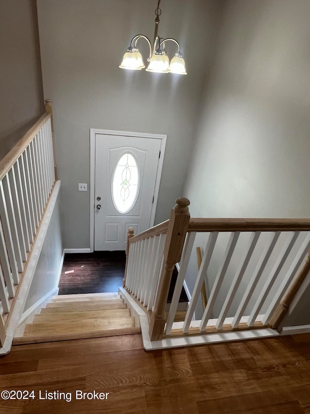 foyer with wood-type flooring and an inviting chandelier