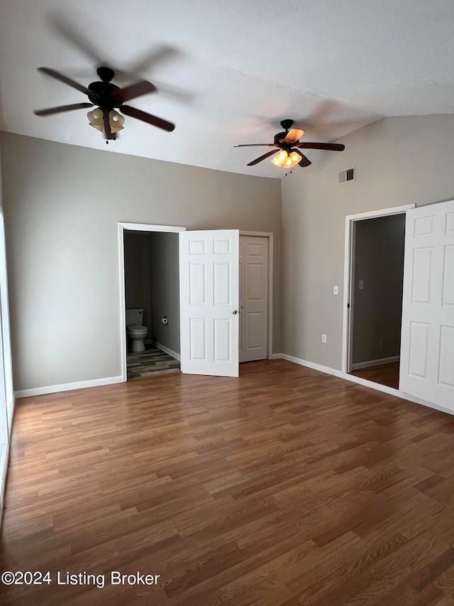 unfurnished bedroom featuring connected bathroom and dark hardwood / wood-style flooring