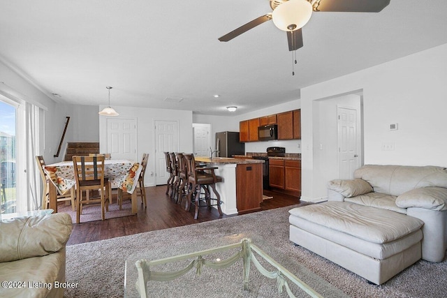 living room with ceiling fan, dark hardwood / wood-style floors, and sink