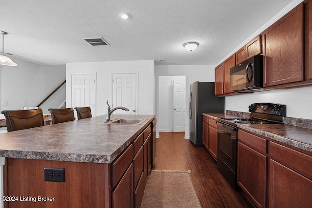 kitchen with dark hardwood / wood-style flooring, black appliances, a center island with sink, and sink