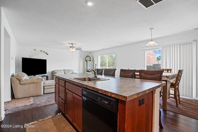 kitchen featuring dishwasher, sink, a healthy amount of sunlight, and an island with sink