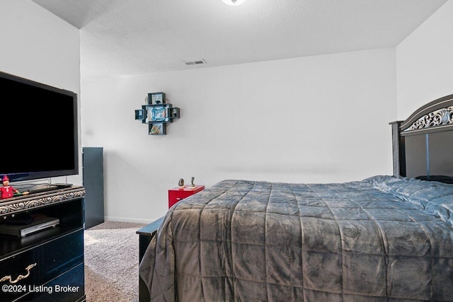 bedroom featuring carpet floors and a textured ceiling