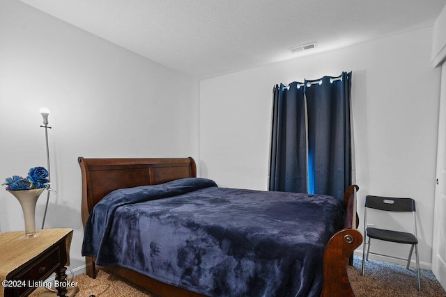 carpeted bedroom with a textured ceiling