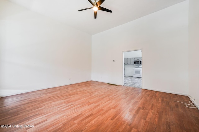 unfurnished room featuring ceiling fan, light hardwood / wood-style flooring, and vaulted ceiling