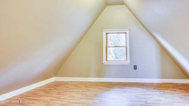 additional living space featuring light hardwood / wood-style floors and lofted ceiling