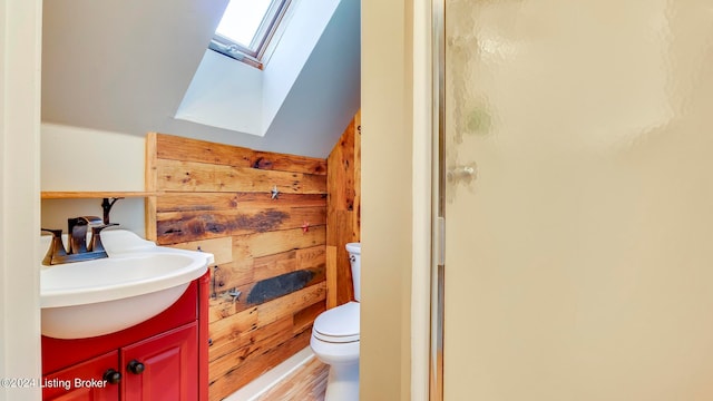 bathroom with hardwood / wood-style flooring, wood walls, a shower with door, vanity, and toilet