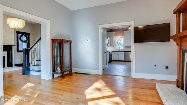 unfurnished living room with light wood-type flooring and a notable chandelier