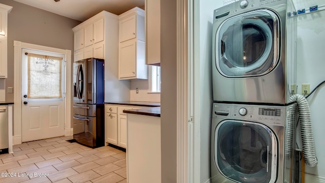 laundry area with stacked washer and clothes dryer and plenty of natural light