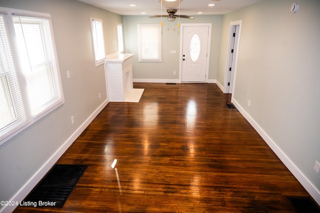 foyer entrance featuring ceiling fan and dark wood-type flooring